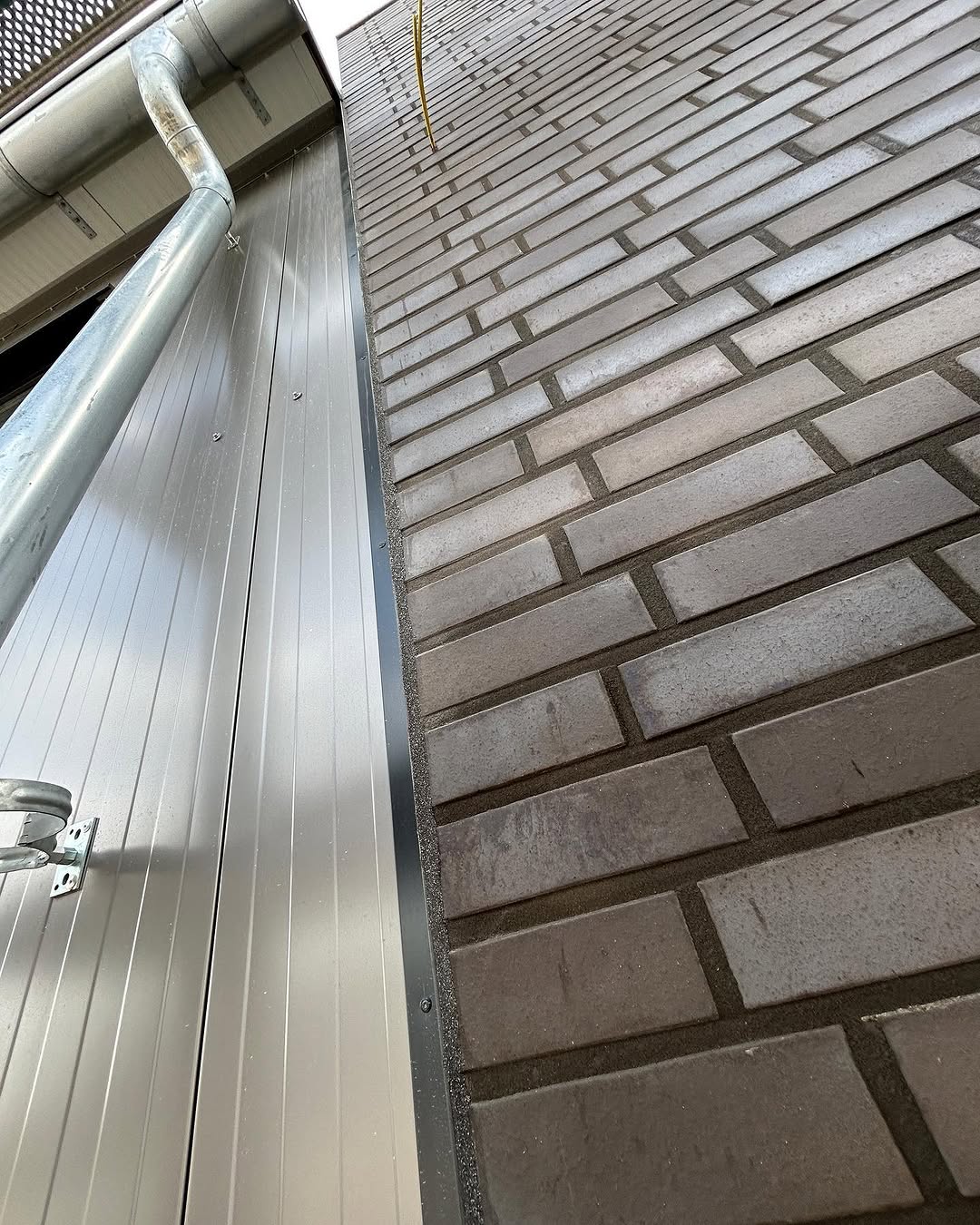 Vertikaler Anschluss zwischen Garagentor und grauem Klinkermauerwerk