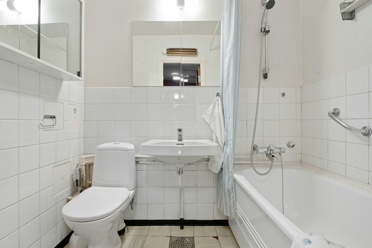 Badezimmer mit gefliesten Anschlüssen an Badewanne und Waschbecken
